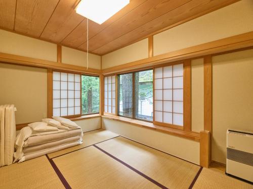 a room with a bed in a room with windows at Runesu Karuizawa - Vacation STAY 92239v in Tsumagoi