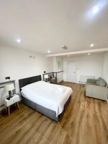 a large bedroom with a large bed and a couch at The Dublin Packet Number 5 Family Room in Holyhead