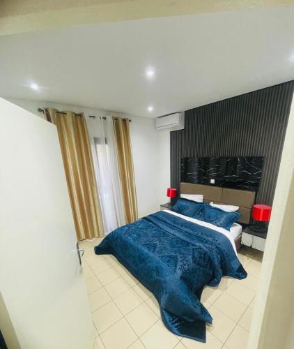 a bedroom with a large blue bed with blue pillows at Saurrier in Motsouémbé