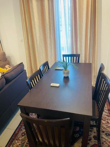 a dining room table with chairs and a plant on it at Saurrier in Motsouémbé