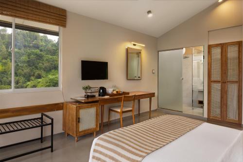 a bedroom with a desk and a television and a bed at The Cubes Ella in Ella