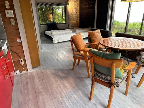 a living room with a table and chairs and a couch at Tiny Camp House Kurage - Vacation STAY 66334v in Kamijinoo