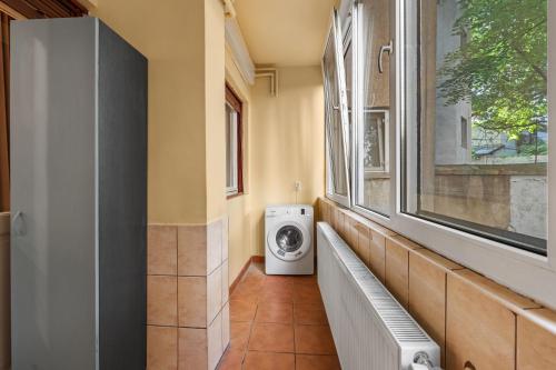 a laundry room with a washing machine and a window at Golden Crown Suite in Bucharest