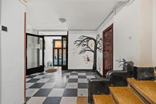 a hallway with a black and white checkered floor at Golden Crown Suite in Bucharest