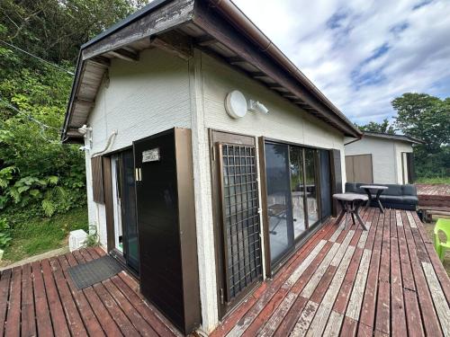 a house with a wooden deck with a table on it at Tiny Camp House Kurage - Vacation STAY 66334v in Kamijinoo