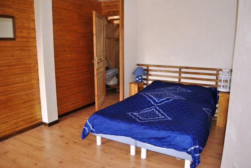 a bedroom with a bed with a blue blanket on it at Chambre sur jardin, proche plage in Bidart