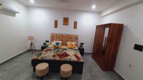 a bedroom with a bed and two stools in it at Cozy and Tranquil nest with wifi and homely care in Greater Noida