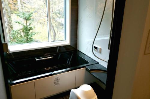 a small bathroom with a window and a sink at KARUIZAWA Funny house - Vacation STAY 69541v in Kutsukake