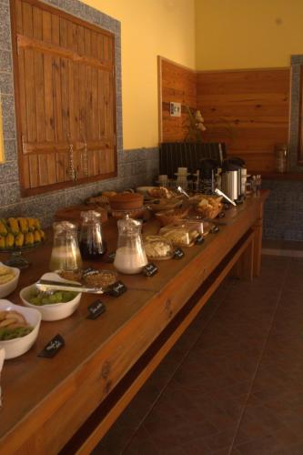 a long wooden counter with food on it at Pousada Toledo in Cunha
