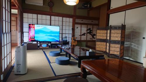 a living room with a large screen tv and a guitar at Kuonsou - Vacation STAY 90948v in Iwada