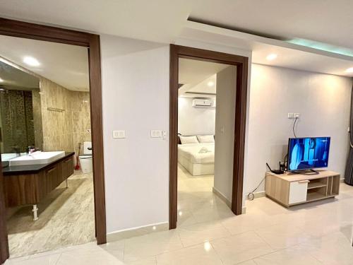 baño con TV y lavabo en Grand Avenue Residence condominium, en Pattaya central