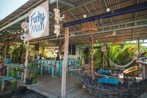 a restaurant with chairs and hammocks on a deck at Funky Moon Kampot in Kampot