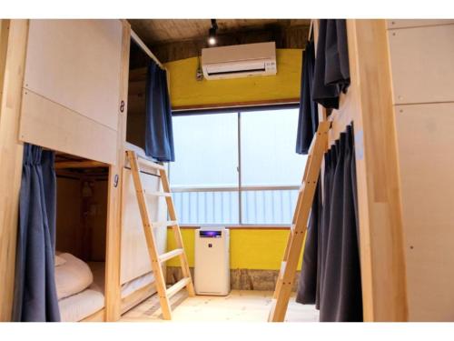 a room with two bunk beds and a ladder at Konyamachi Guest House Kuku - Vacation STAY 72725v in Takamatsu