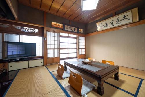 a dining room with a table and chairs and a television at Chizu - Vacation STAY 83974v in Mitoyo