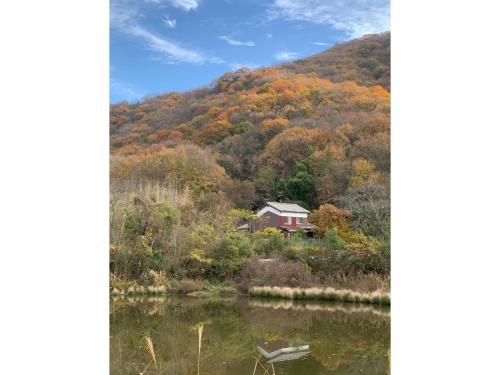 a house on a hill next to a lake at Ensoh - Vacation STAY 13339 in Tamano