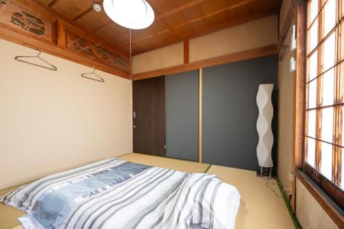 a bedroom with a bed in a room with windows at Chizu - Vacation STAY 83880v in Mitoyo
