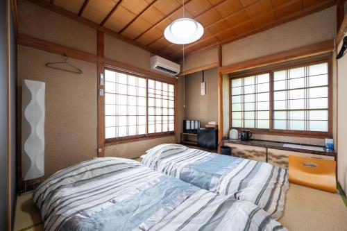 a bedroom with two beds in a room with windows at Chizu - Vacation STAY 83880v in Mitoyo