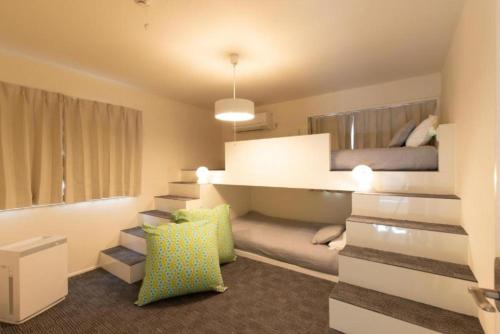 KouriにあるBBASE KOURI iSLAND - Vacation STAY 77541vの階段付きの部屋(ベッド1台、ソファ付)