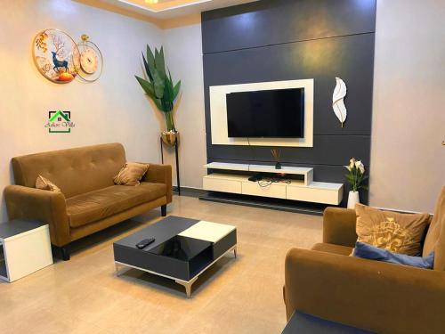Una televisión o centro de entretenimiento en Tastefully furnished two bedrooms Garki