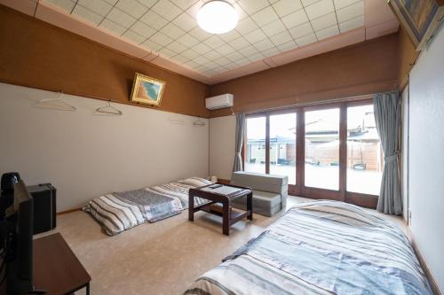 a bedroom with two beds and a desk and a window at Chizu - Vacation STAY 83949v in Mitoyo