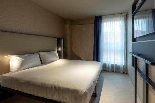 a hotel room with a bed and a window at Scarlatti Hotel Milano in Milan