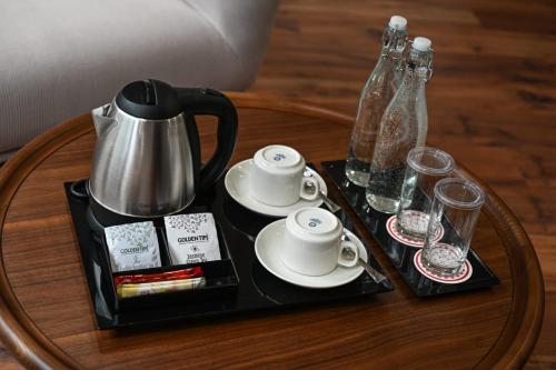 a coffee table with a tray with a tea kettle and cups at Swiss Boutique Thimphu in Thimphu