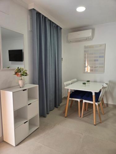 ein Wohnzimmer mit einem weißen Tisch und einem Schreibtisch in der Unterkunft Casa San Pedro 14 in Genalguacil