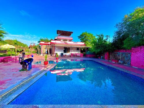a swimming pool with a person working in the water at Stay Farm house Villa with pool in Gurgaon in Bhundsi