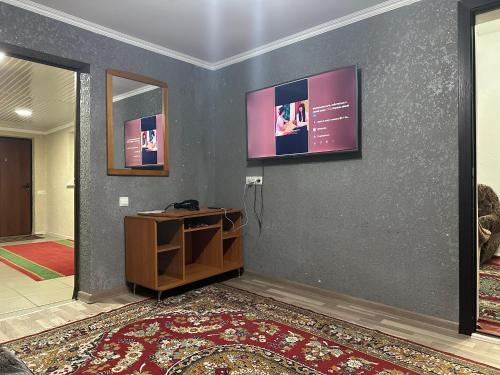 Habitación con pared, mesa y espejo. en Aport 24, en Karakol