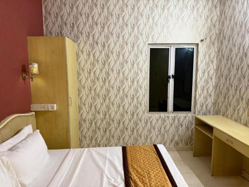 Un dormitorio pequeño con una cama y una ventana. en Western e-Inn, en Bangalore