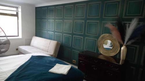 a bedroom with a bed and a chair and a mirror at gourock blissful apartment with 3 bedrooms in Gourock
