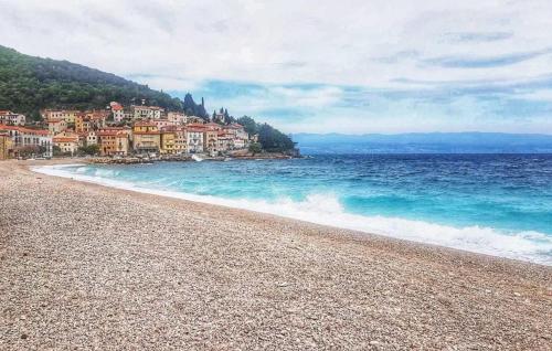 a beach with a town and the ocean at Apartman Zora 2 by Villas Guide in Mošćenice