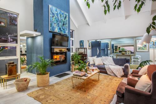 a living room with a couch and a fireplace at Villa Blau -Stunning Beach Front House Grotto Bay Private Nature Reserve West Coast in Grotto Bay