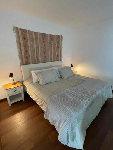 a bedroom with a large bed with two lamps on it at Frente al mar in Montevideo