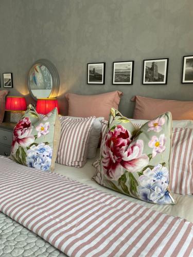 a bedroom with a bed with pink and white pillows at The Mayfield Hotel in Blackpool