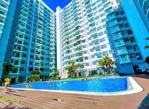 ein Pool vor zwei großen Gebäuden in der Unterkunft Love House - Căn hộ 2 phòng ngủ tại Nera Garden Huế in Thôn Văn Dương