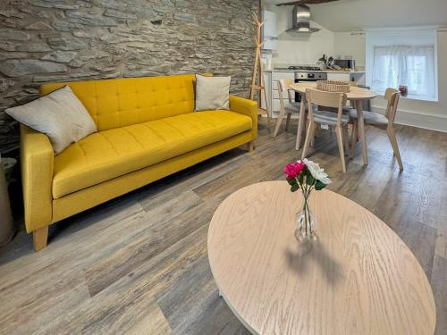 a living room with a yellow couch and a table at Apartment Two - Uk49592 in Bala