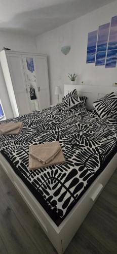 a large bed with a black and white comforter at Kuća za odmor Tena in Krapanj