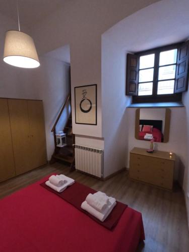 a bedroom with a red bed and a window at Milton House in Arezzo