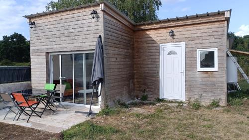a tiny house with a patio and a white door at Petite maison calme près de la mer in Binic-Etables-sur-Mer