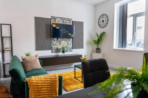 a living room with a green couch and a chair at Stylish 3BR 18mins to Peak District,Free, Parking Wifi,Netflix ,Sky Sports in Ashton under Lyne