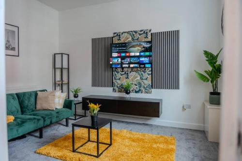 a living room with a green couch and a tv at Stylish 3BR 18mins to Peak District,Free, Parking Wifi,Netflix ,Sky Sports in Ashton under Lyne