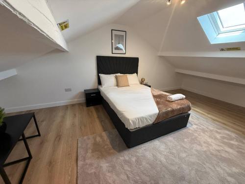 a bedroom with a large bed in a attic at Stylish 3BR 18mins to Peak District,Free, Parking Wifi,Netflix ,Sky Sports in Ashton under Lyne