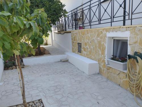 a courtyard with a stone building with a fireplace at παραδοσιακό και ήρεμο καταλυμα in Salamís