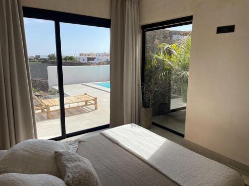 Un dormitorio con una cama y vista a un patio. en Villa Victoria El Roque, en Roque