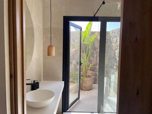 Un baño con un lavabo blanco y un espejo. en Villa Victoria El Roque, en Roque