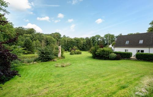 a large yard with a white house and trees at Awesome Apartment In Nimtofte With Wifi in Nimtofte