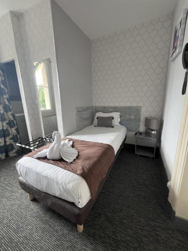 Ein Bett oder Betten in einem Zimmer der Unterkunft Hôtel L'Univers