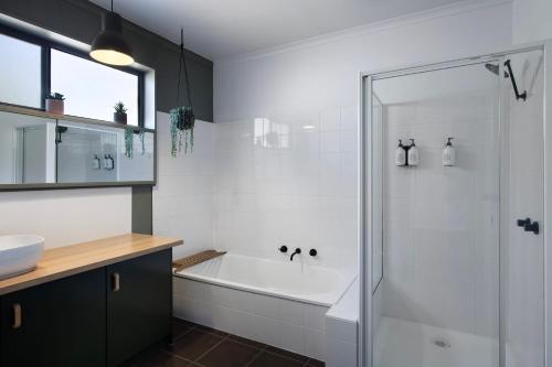a bathroom with a bath tub and a sink at The Bach- dog friendly with lovely bush views in Hepburn