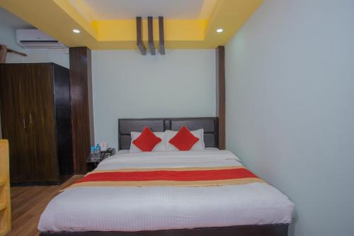 a bedroom with a large bed with red pillows at OYO 260 Hotel Cultural Inn in Kathmandu
